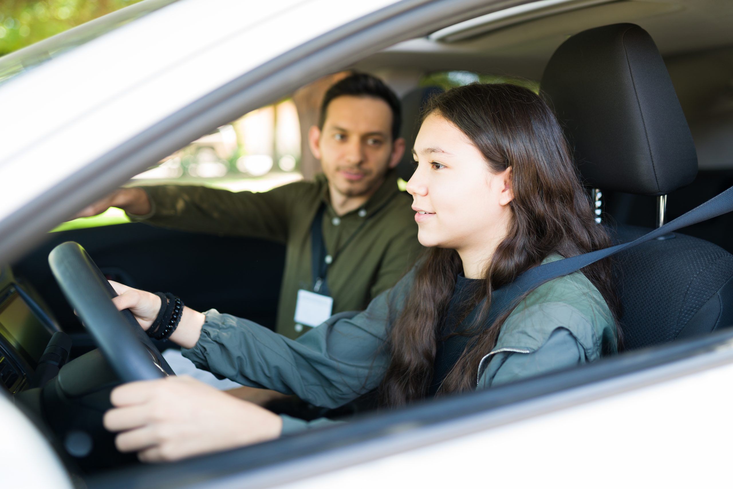 beautiful teen girl doing her driving exam with a school driving instructor